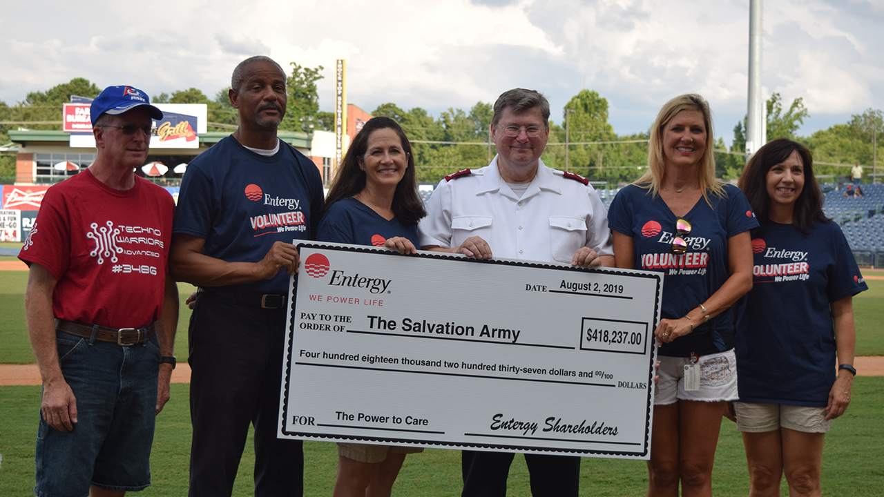 Entergy employees present Major Michael Hawley of the Salvation Army a check for The Power to Care program.